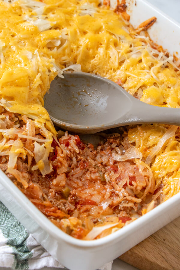 unstuffed cabbage roll casserole in baking dish with a scoop of the finished dish removed