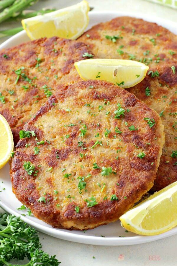 Salmon Patties on a plate with lemon wedges.