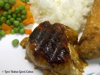 Teriyaki Chicken with Homemade Teriyaki Sauce with egg roll, white rice, peas and carrots on plate