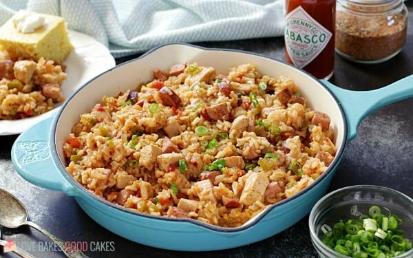 Jambalaya in teal pan with Tabasco bottle and green onions. 