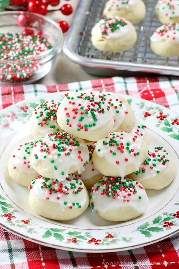 Italian Anise Cookies stacked on plate with red and green sprinkles. 