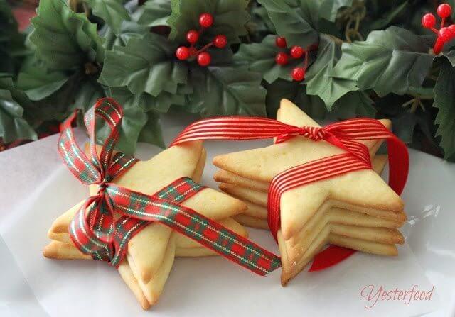 Cornmeal Stars with Orange Glaze stacked and wrapped with ribbons on plate.