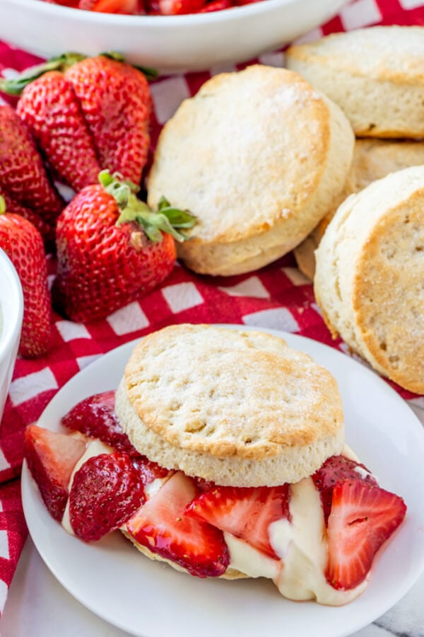 strawberry shortcake on plate with shortcakes and strawberries in background