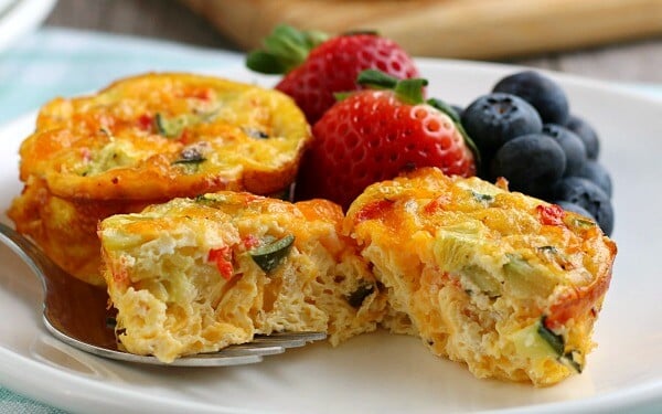 muffin tin egg split in half on plate with berries