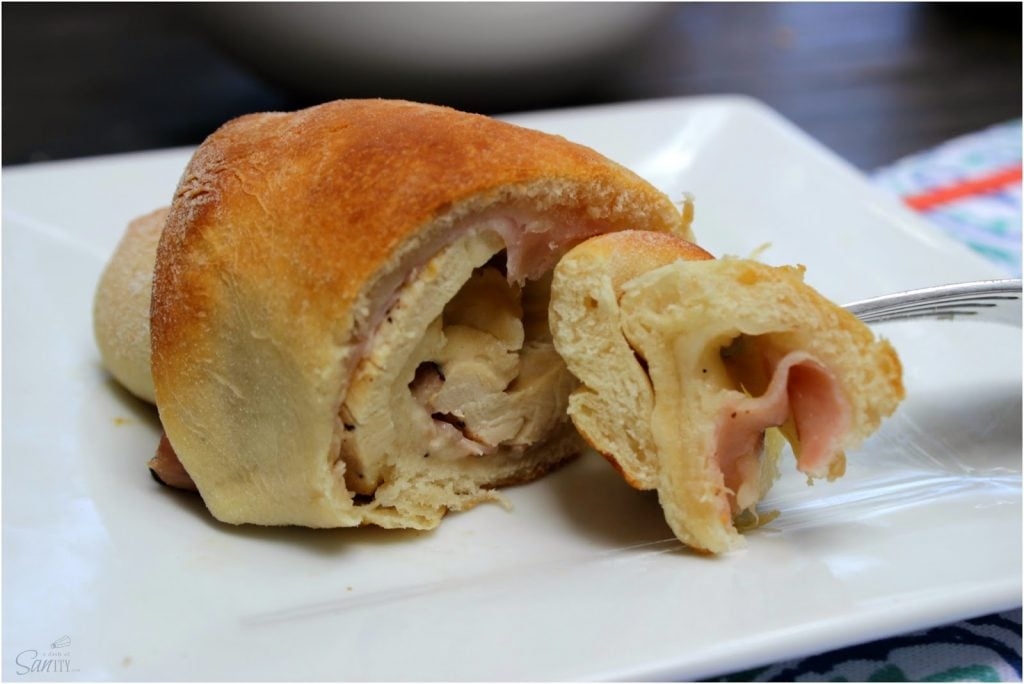 Chicken Cordon Bleu Crescent Roll on a plate with a fork removing a piece.