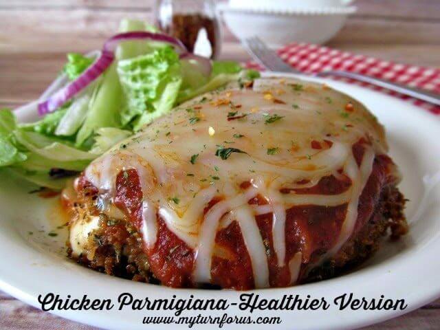 Chicken Parmigiana on a plate with a salad and a fork.