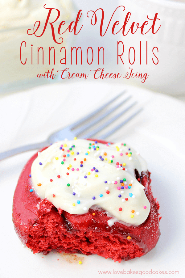Red Velvet Cinnamon Roll with Cream Cheese Icing on a plate with a fork.