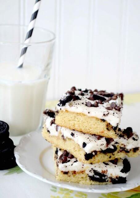 Cookies & Cream Texas Sheet Cake on a plate with a glass of milk.