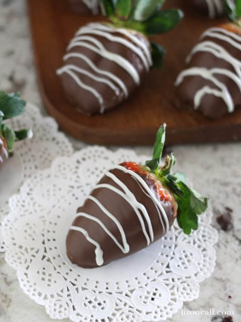  Chocolate Covered Strawberries on a cutting board and on a napkin.