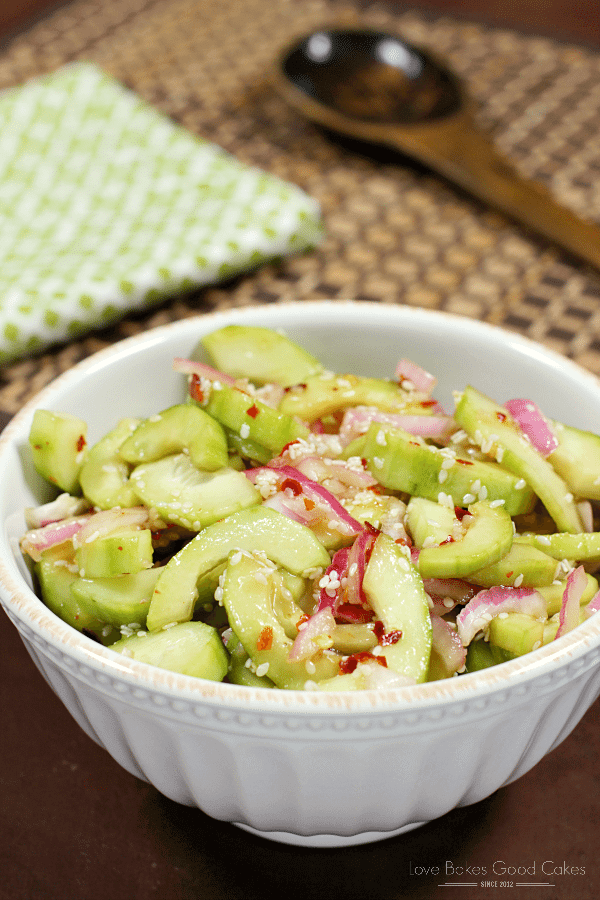 Asian Cucumber Salad in a white bowl with a spoon.