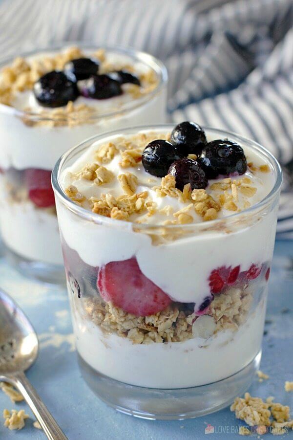 Fruit and Yogurt Breakfast Parfait in two glasses with a spoon.