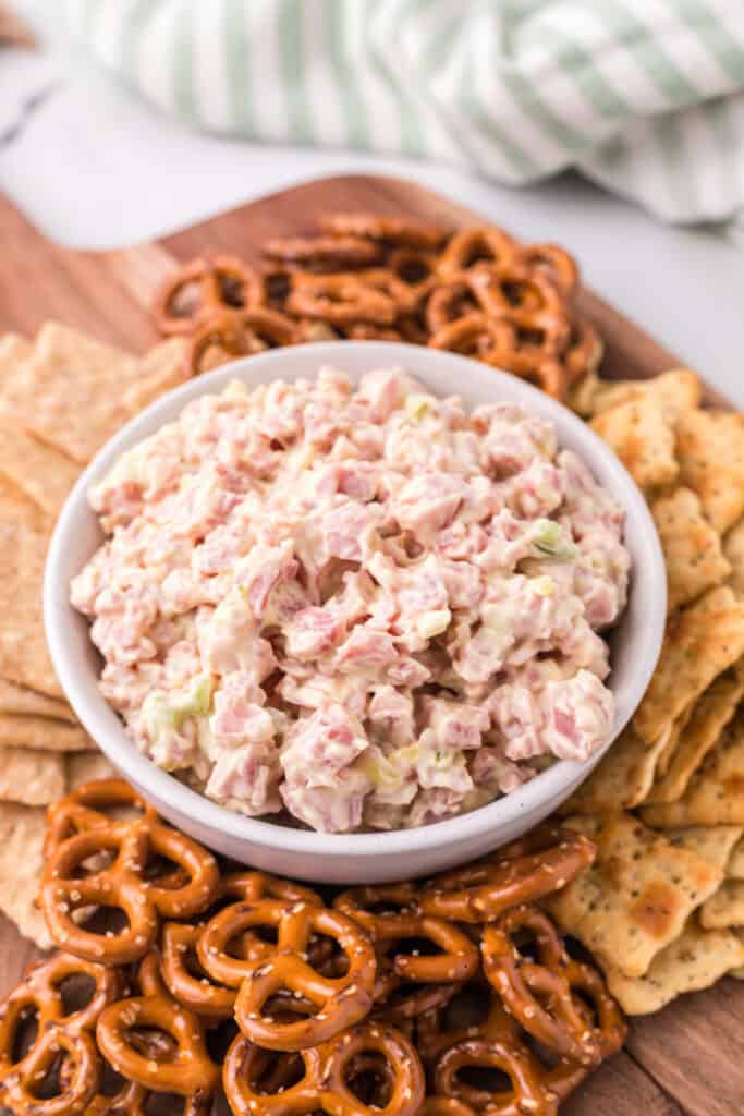 ham salad in bowl with assorted chips, crackers, and pretzels for dipping