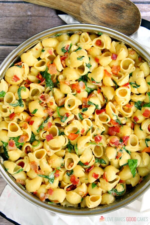 One Pot Creamy Bacon Spinach Pasta i en stegepande med en ske.