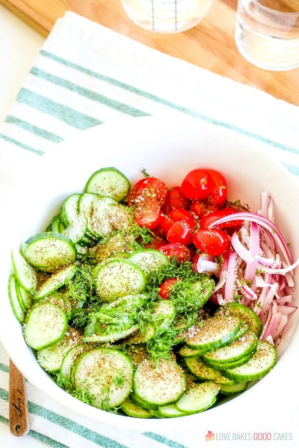 cucumbers, tomatoes, onions, and seasonings in bowl