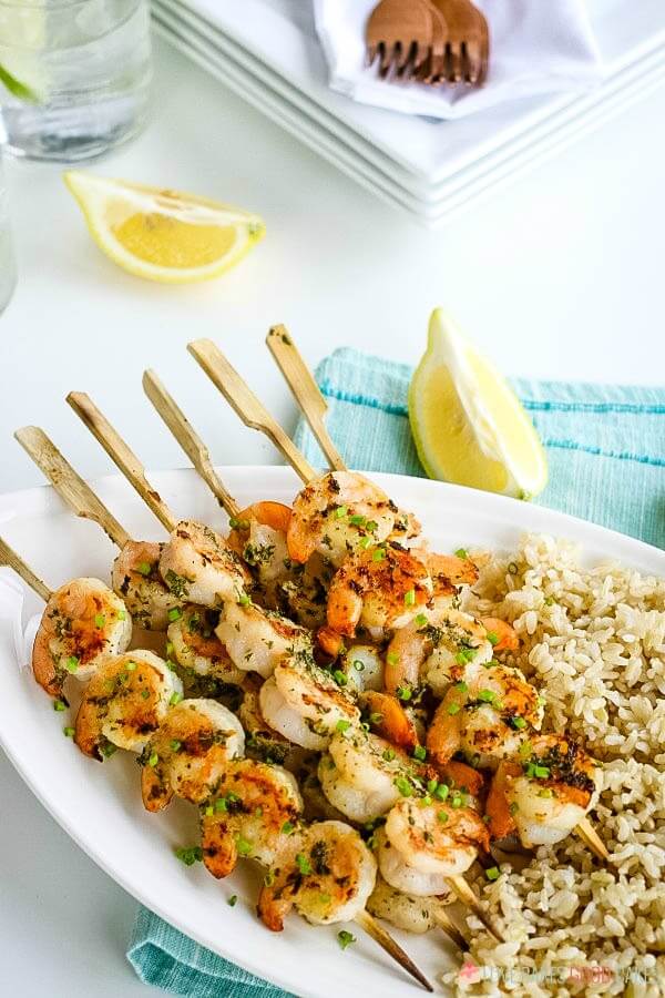 Grilled Shrimp Kabobs served with brown rice and lemon wedges.