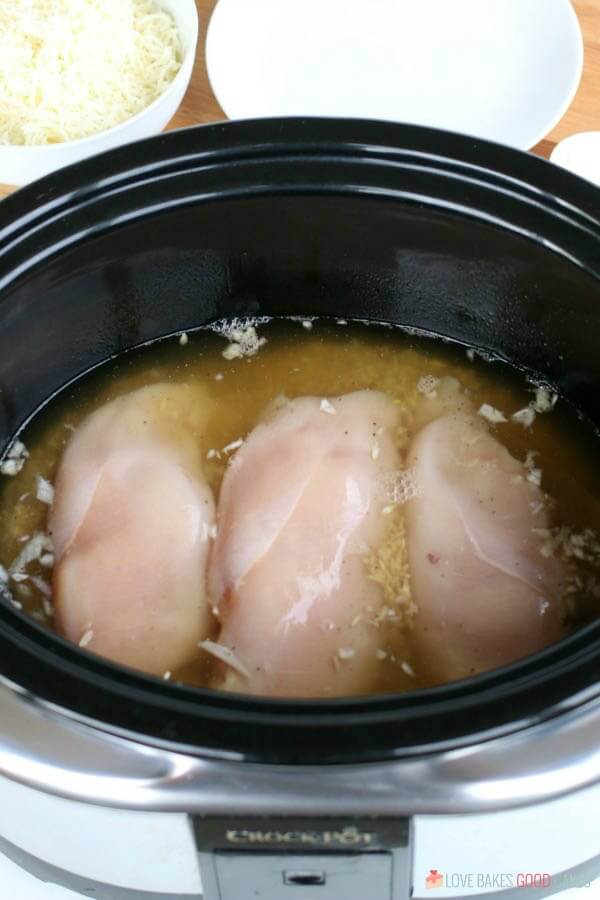 Chicken stock added to slow cooker for chicken and rice.