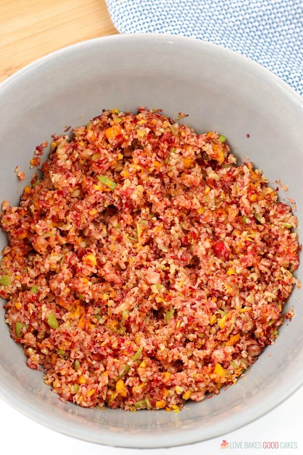 A top down view of the chopped ingredients for cranberry relish mixed together in a bowl. 