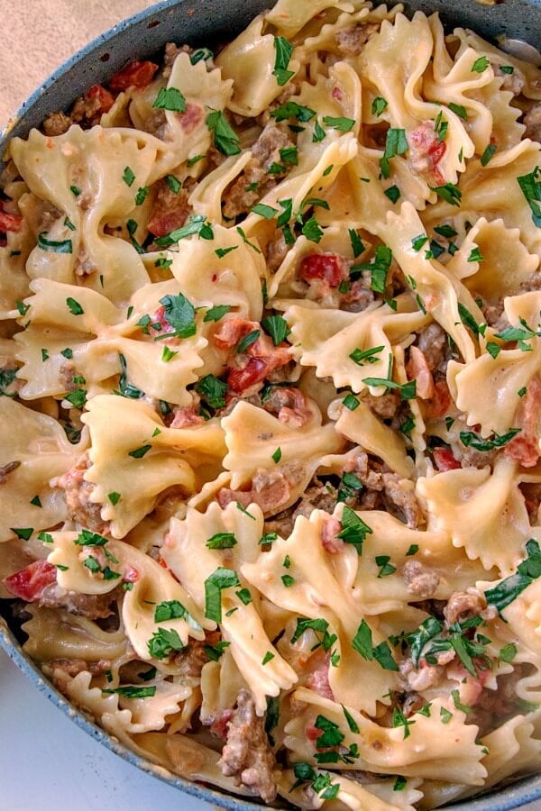 italian sausage and bow tie pasta in pan