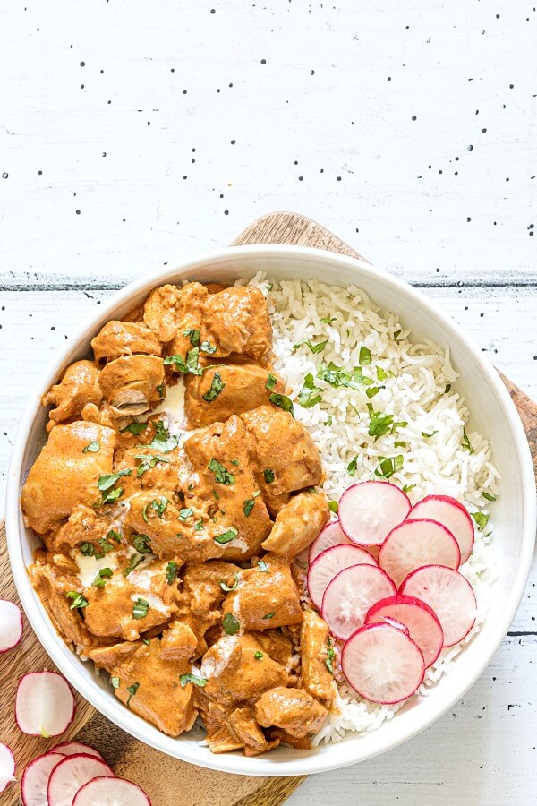 instant pot butter chicken in white bowl on white wood background