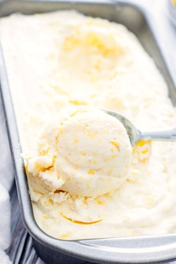 pineapple ice cream after being frozen in pan with scoop on top
