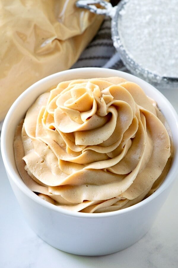 closeup of creamy peanut butter frosting in small white bowl