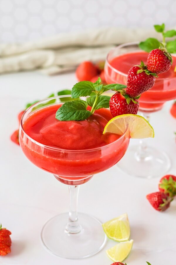 rum, strawberries, and lime juice blended to make Strawberry Daiquiris in glass
