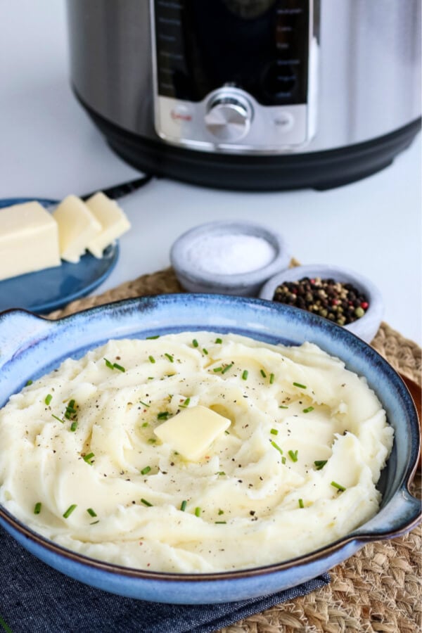 bowl of mashed potatoes with electric pressure cooker in background