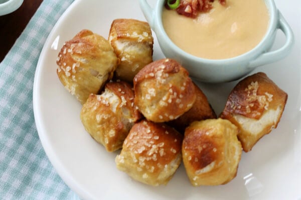 pretzel bites on white plate with cheese dip