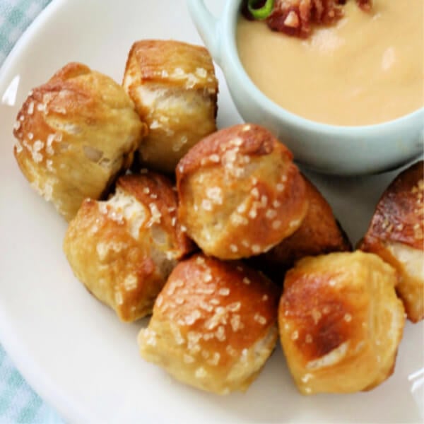 pretzel bites on white plate with cheese dip