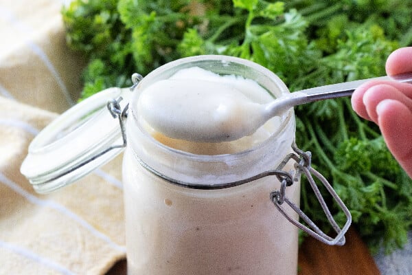 primo piano di uno sppone che tiene un sostituto della crema di zuppa sul barattolo