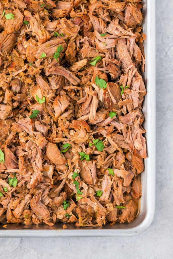 closeup of a sheet pan with cooked mexican carnitas meat