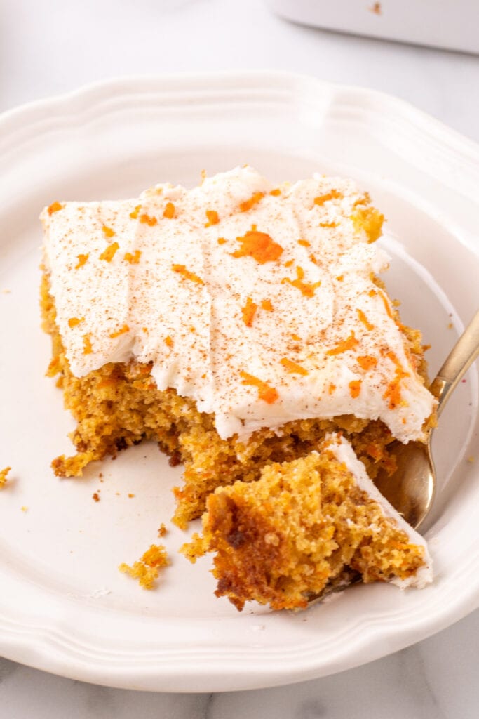 carrot sheet cake on plate with a bite of cake on a fork