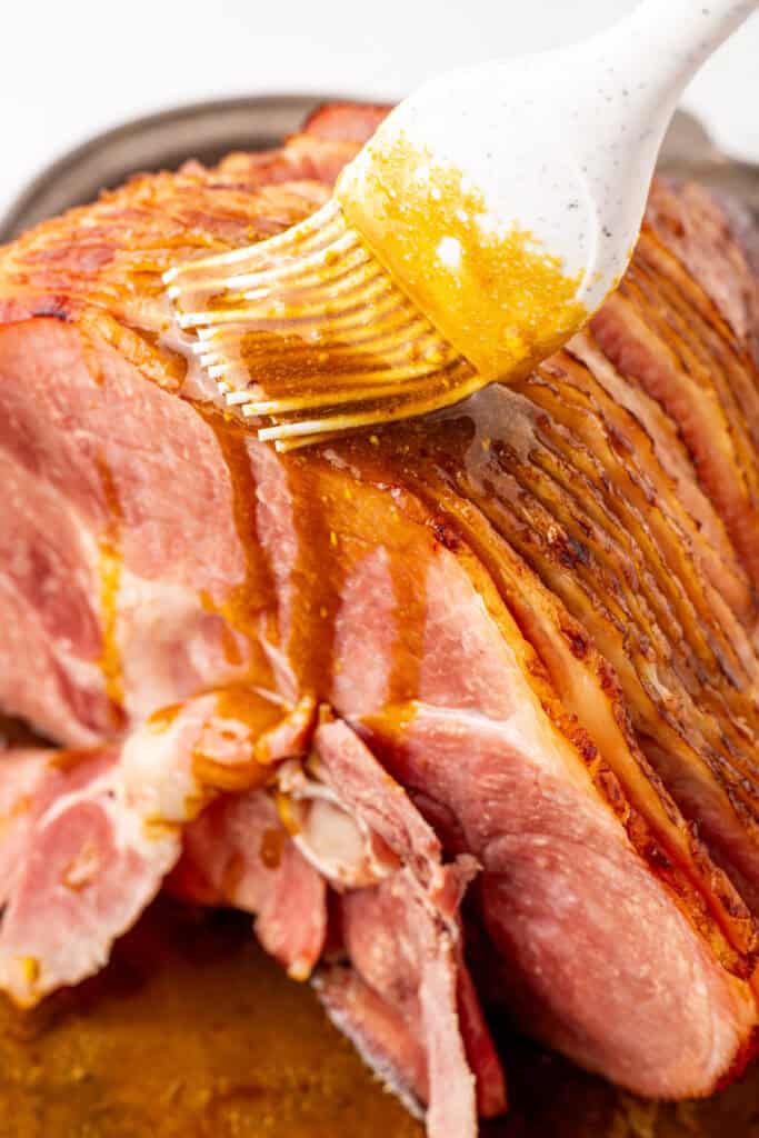 coca cola glaze being brushed onto ham