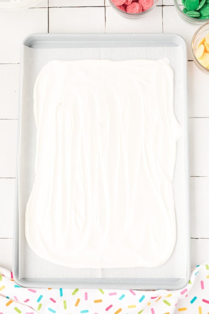 Melt and pour the white chocolate out onto the prepared pan and spread it out using an offset spatula or the back of a spoon to form a large rectangle.